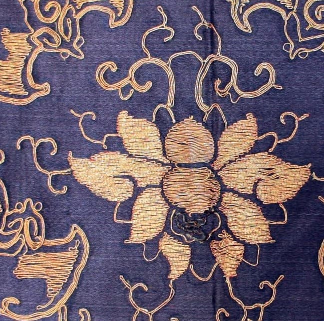 Principal lotus head of a gold-brocaded scrolling design